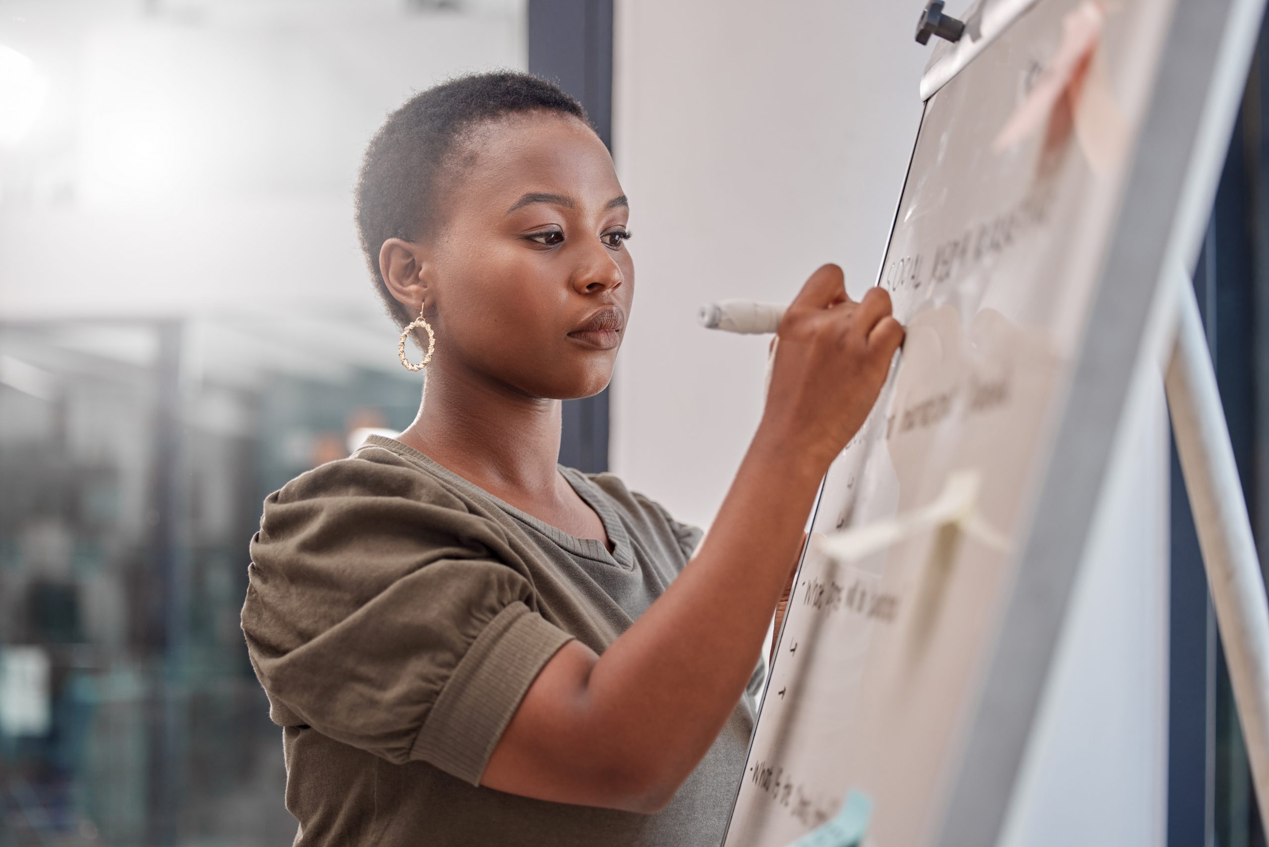 Writing, board and business black woman with notes for planning, brainstorming ideas and problem solving. Corporate, presentation and person in meeting for project, research and schedule in office